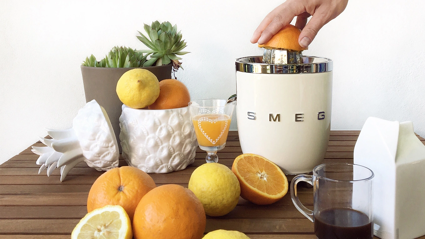 Orangen werden mit der smeg cjf01creu zitruspresse ausgepresst